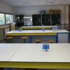 Laboratorio de química de un instituto de secundaria en Zaragoza con mesas de trabajo, fregaderos, taburetes y armarios.
