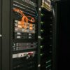 Armarios de servidores y equipos de red con cables de conexión en una sala de un centro de datos.