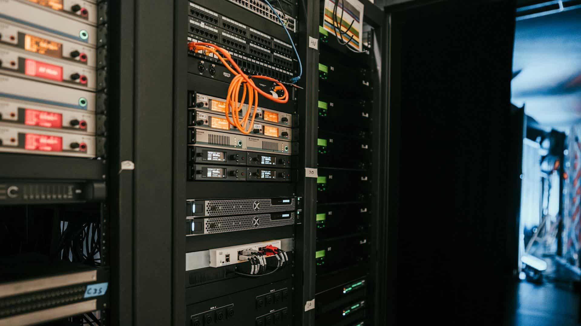 Armarios de servidores y equipos de red con cables de conexión en una sala de un centro de datos.