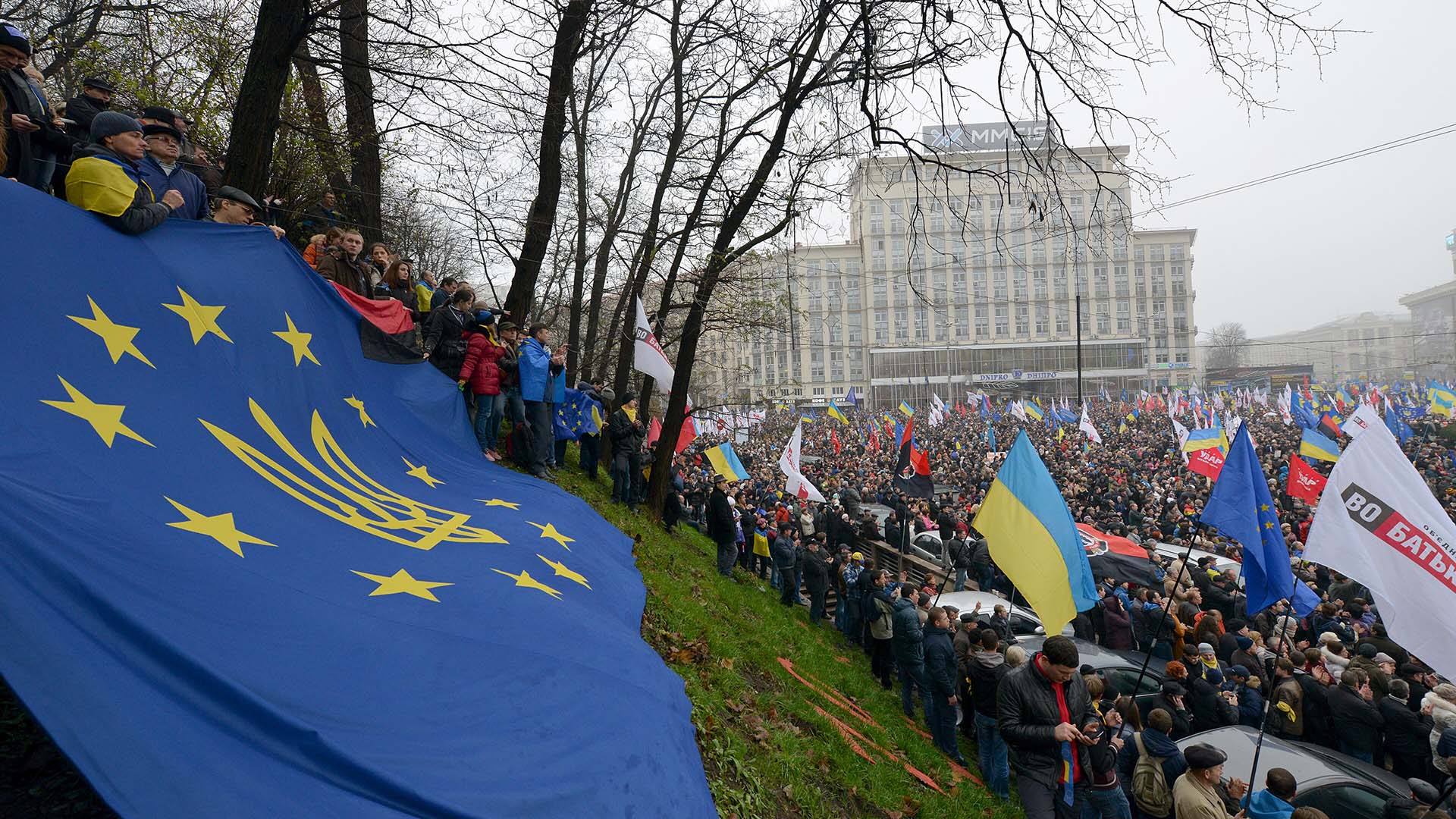 Multitudinaria manifestación en una plaza a favor de la UE en Kiev con banderas de Ucrania y de la UE con el escudo del país en primer plano.