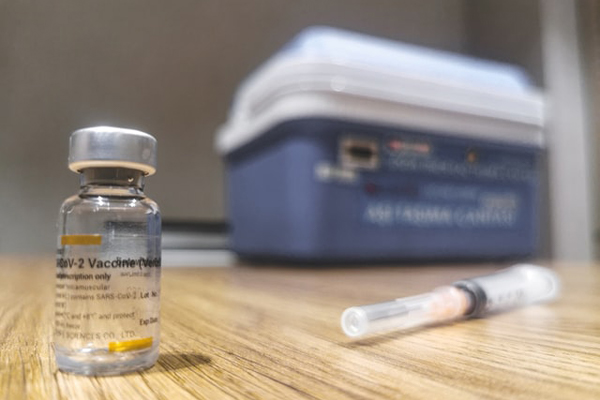 COVID-19 vaccine and a syringe. Photo: Mehmet Turgut Kirkgoz (@tkirkgoz)