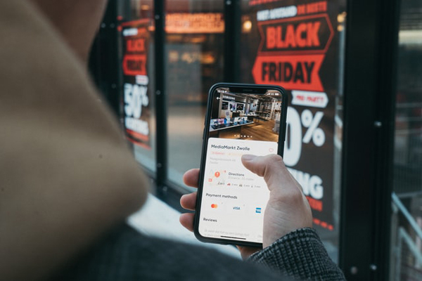 Person holding a mobile phone on Black Friday shopping. Photo: CardMapr.nl (@cardmapr)