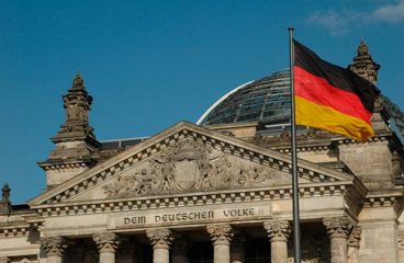 German elections: more continuity than change. German flag and the federal parliament in the background, Berlin. Photo: Herman (CC BY-SA 2.0)