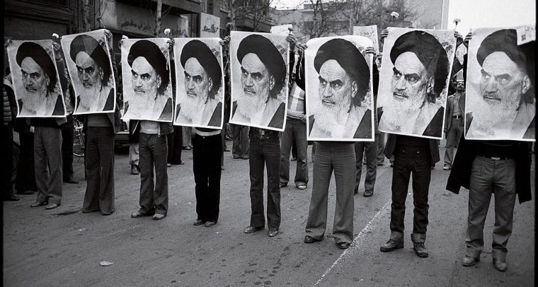 Una fila de hombres sostienen la imágen del ayatolá Jomeini durante una manifestación en Irán (1978). Fotografía escaneada, autor desconocido (Wikimedia Commons / Dominio público). Blog Elcano