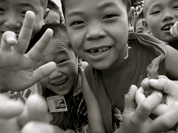 Niños ante la cámara en el sureste de China. Foto: Chris Suderman / Flickr.  Licencia Creative Commons Reconocimiento-No Comercial-Sin Obras Derivadas.