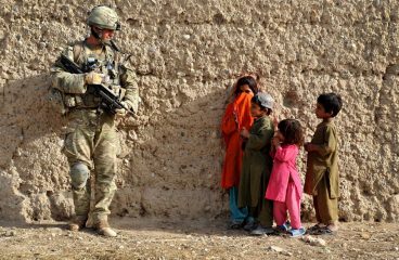 Soldado habla con niños mientras patrulla en Afganistán. Foto: CC BY-NC 2.0.
