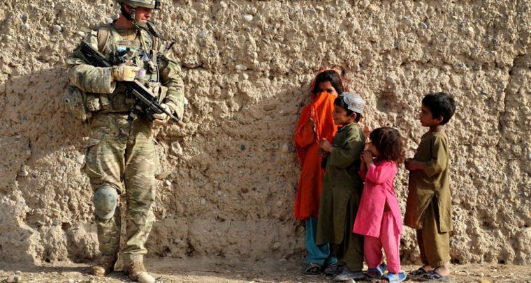 Soldado habla con niños mientras patrulla en Afganistán. Foto: CC BY-NC 2.0.