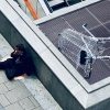 La lucha contra la desigualdad . Mujer con chaqueta y pantalones negros tumbada en unas escaleras de hormigón gris en Viena (Austria). Foto: Arno Senoner (@arnosenoner). Blog Elcano