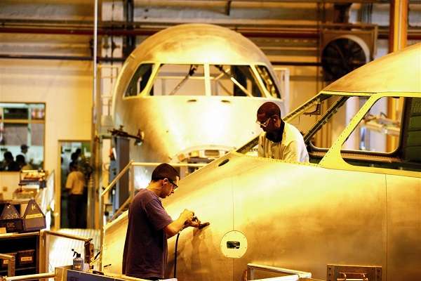 Técnicos trabajan en la línea de montaje de un jet en la empresa aeronáutica brasileña Embraer. Foto: Embraer