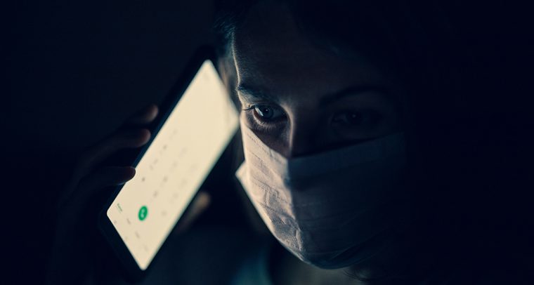 Infodemia. Persona con mascarilla y un teléfono móvil. Foto: engin akyurt (@enginakyurt). Blog Elcano