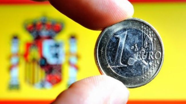 A euro coin with the Spanish national flag in the background. Elcano Blog