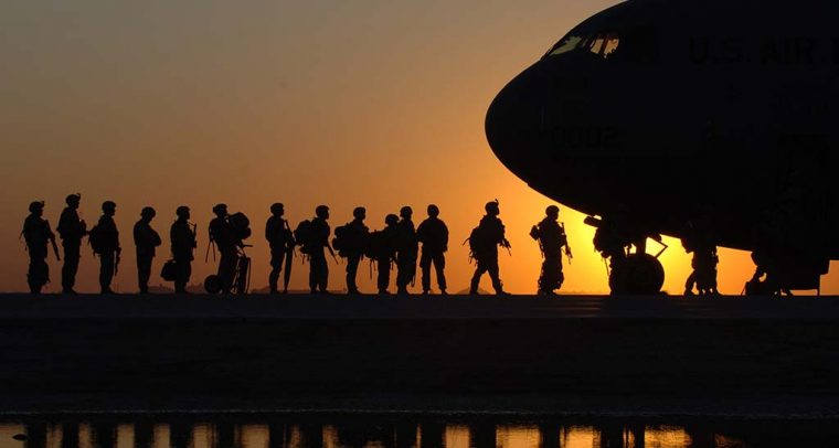 Soldados en fila para subir a un avión.