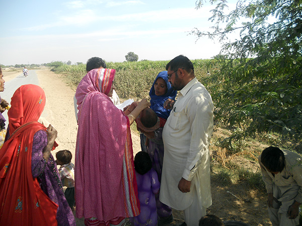 Doctora suministra la vacuna de la polio a un niño en un campo de algodón en Pakistán. Foto: Ambreen Chaudhry / CDC Global (CC BY 2.0)