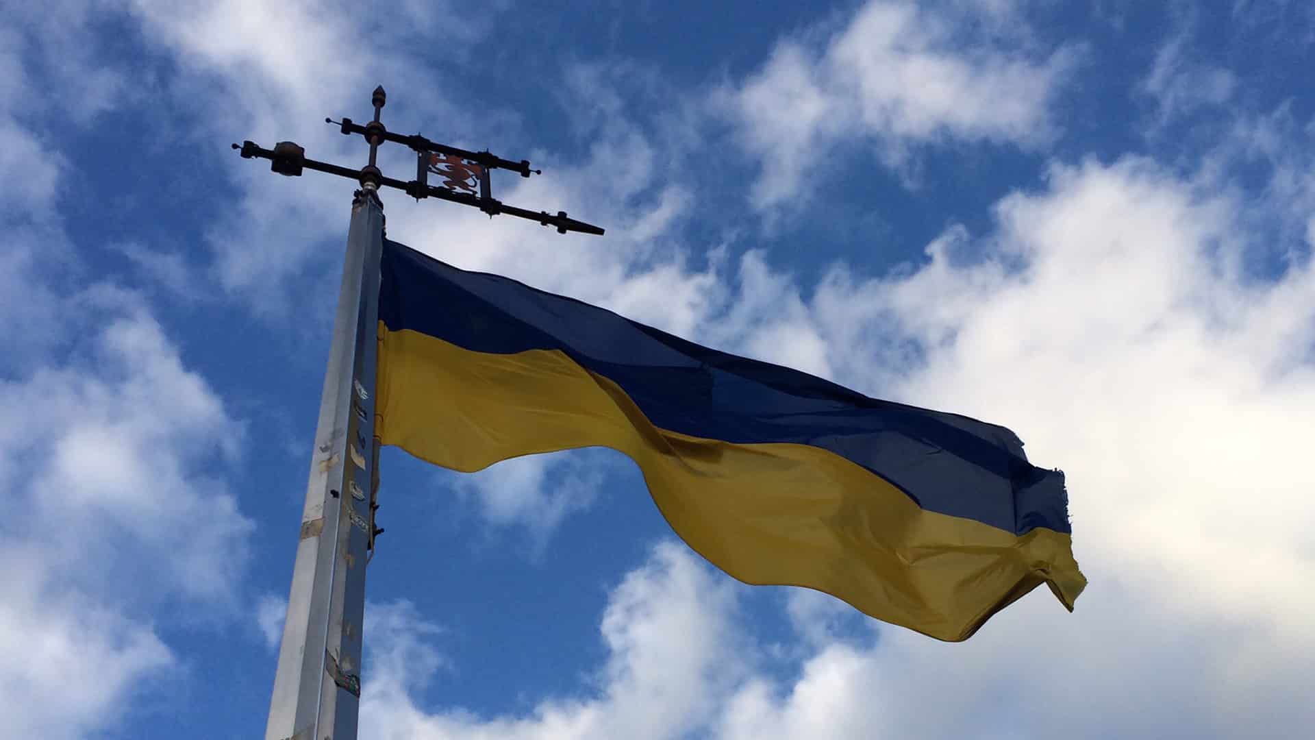 Primer plano de la bandera de Ucrania ondeando en un mástil en la cima de la colina del Castillo Alto de Leópolis / Lviv.