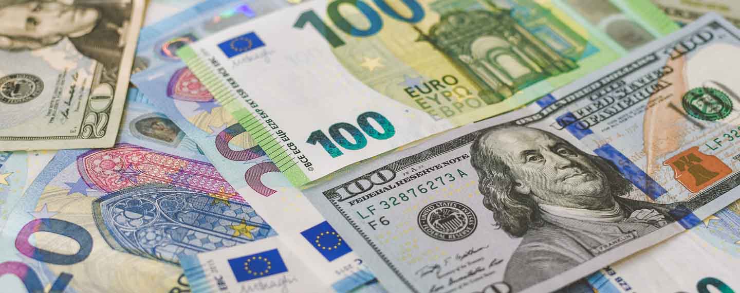 Inversiones. Billetes de 100 euros y de 100 dólares colocados horizontalmente entre una variedad de billetes