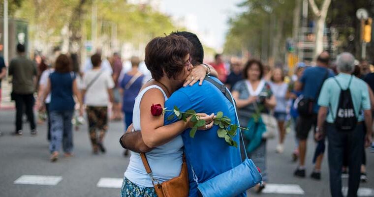 Una mujer con una rosa roja y un hombre se abrazan en la manifestación en Barcelona contra el terrorismo bajo el lema “No tenemos miedo, 26 de agosto de 2017