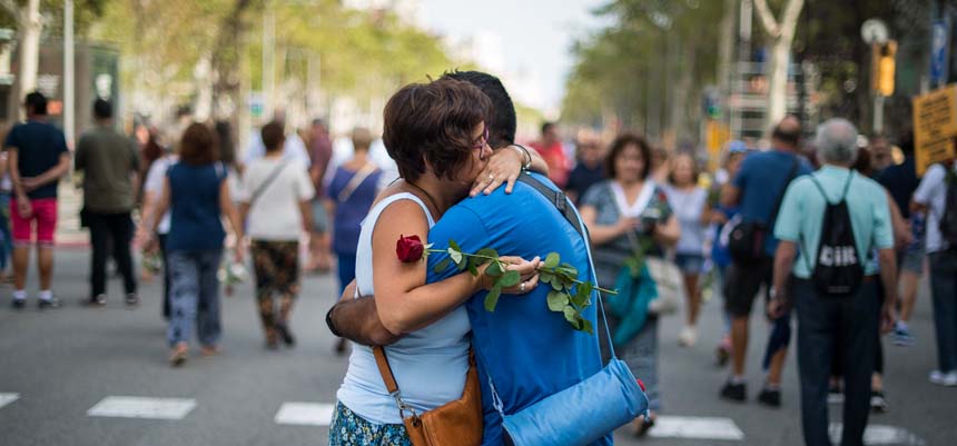 Una mujer con una rosa roja y un hombre se abrazan en la manifestación en Barcelona contra el terrorismo bajo el lema “No tenemos miedo, 26 de agosto de 2017
