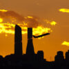 A plane departs from Adolfo Suárez Madrid-Barajas airport, the Cuatro Torres Business Area in the background (Madrid, Spain)