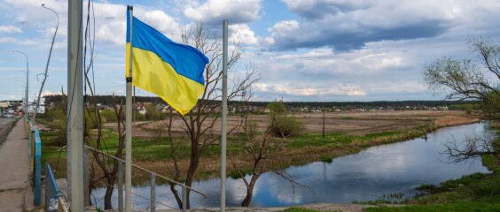 Una bandera de Ucrania ondea junto a un puente sobre el río Irpin, al lado de Hostomel, en las afueras de la ciudad de Kyiv