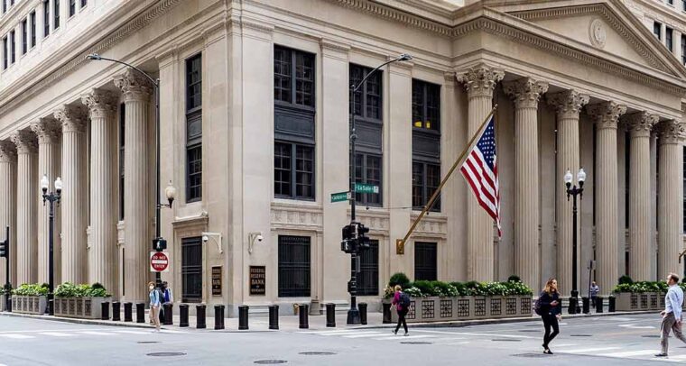 Inflación y estabilidad financiera, Personas cruzando la calle en un semáforo frente al edificio de la sede del Banco de la Reserva Federal en Chicago, Illinois (EEUU)