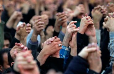 Intertwined hands raised to heaven of worshippers during Friday prayers in Tehran, capital of the Islamic Republic of Iran, with Ayatollah Khamenei’s speech