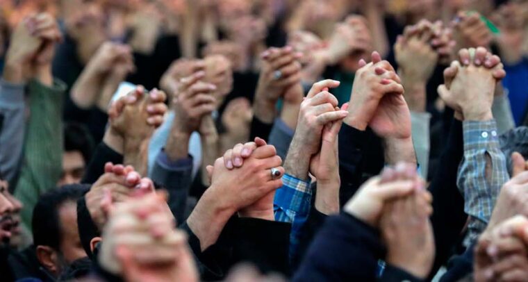 Manos entrelazadas elevadas al cielo de los feligreses durante la oración de los viernes en Teherán, capital de la República Islámica de Irán con el discurso del ayatolá Jamenei