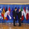Pedro Sánchez (presidente del Gobierno de España) y Jean-Claude Juncker (presidente de la Comisión Europea) en la recepción de una reunión informal sobre asuntos de migración y asilo en Bruselas, Bélgica. Al fondo las banderas de los Estados miembros de la UE (24/06/2018).