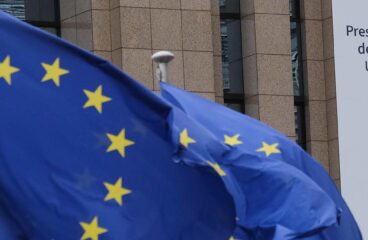 Banderas de la UE y banner con el logo de la Presidencia Española del Consejo de la UE como decoración en el edificio Europa en Bruselas, Bélgica