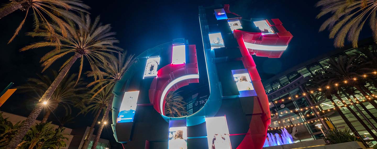 Estatua del logotipo de TikTok con proyecciones de vídeos en móviles en la convención VidCon 2022 en el centro de convenciones de Anaheim en EEUU