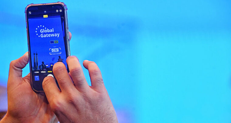 Hands holding a smartphone with the inscription “Global Gateway” (name of an EU initiative) on the screen
