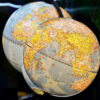 Fotografía de enfoque superficial de dos globos terráqueos de escritorio. En el globo en primer plano se distingue el Océano Índico. Sur global
