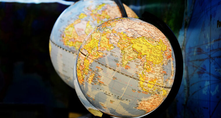 Fotografía de enfoque superficial de dos globos terráqueos de escritorio. En el globo en primer plano se distingue el Océano Índico. Sur global
