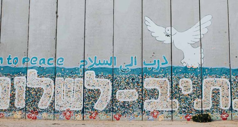 A wall at Netiv HaAsara facing the Gaza border reads the words “Path to Peace” in Hebrew, Arabic, and English. Netiv HaAsara is a moshav in southern Israel. Located in the north-west Negev, it nearly borders the Gaza Strip