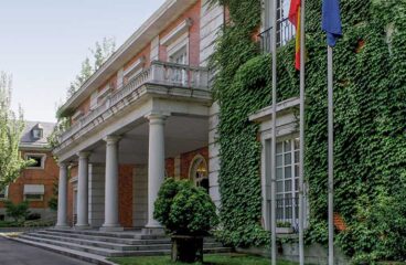 Diagonal view of the façade of the Council of Ministers Pavilion in the Moncloa Complex, with the Spanish and EU flagpoles. Challenges