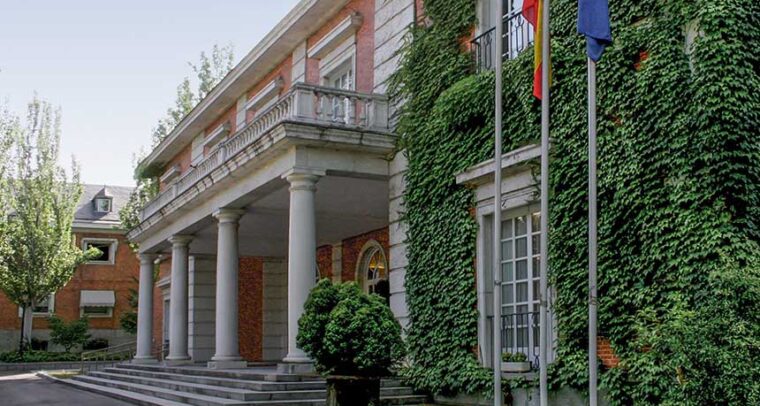 Diagonal view of the façade of the Council of Ministers Pavilion in the Moncloa Complex, with the Spanish and EU flagpoles. Challenges