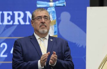 Bernardo Arévalo de León, presidente electo de Guatemala, aplaude en el plenario de la segunda reunión de transición realizada el 11 de septiembre de 2023. Al fondo el estandarte de la bandera del país