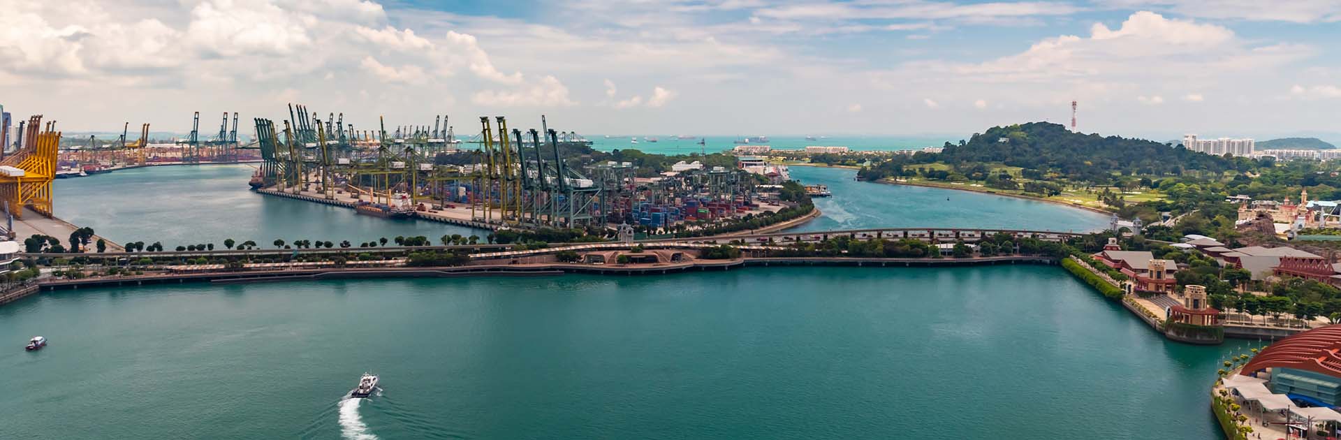 El enorme puerto logístico y comercial de Singapur, con un montón de grúas para mover contenedores, enormes barcos de carga en el fondo, centros comerciales y rascacielos en la isla de entretenimiento cercana. Economía mundial