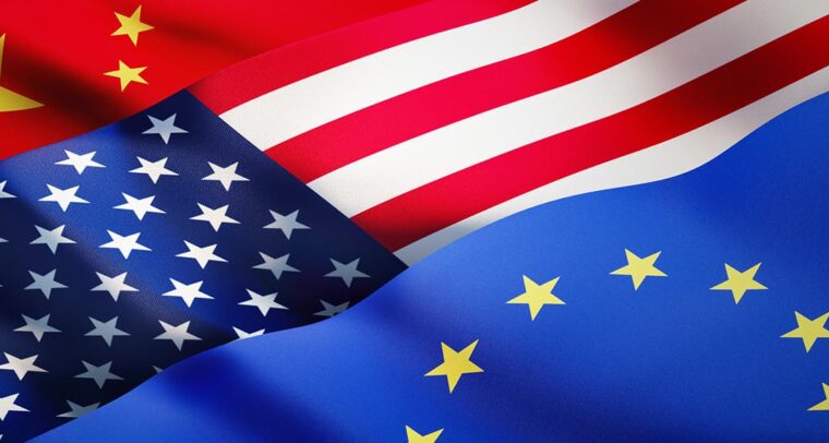Banderas china, estadounidense y europea ondeando a la luz del sol como fondo. China, EEUU y la UE conforman un triángulo estratégico