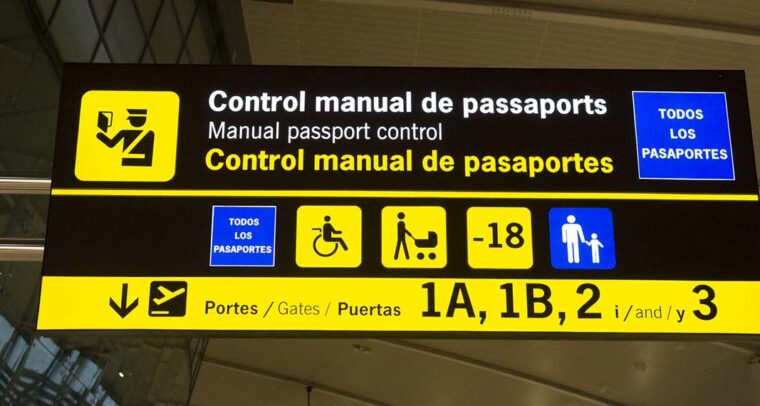 Close-up of an information panel at manual passport control at Barcelona-El Prat airport. The panel is in Catalan, Spanish and English. Immigration
