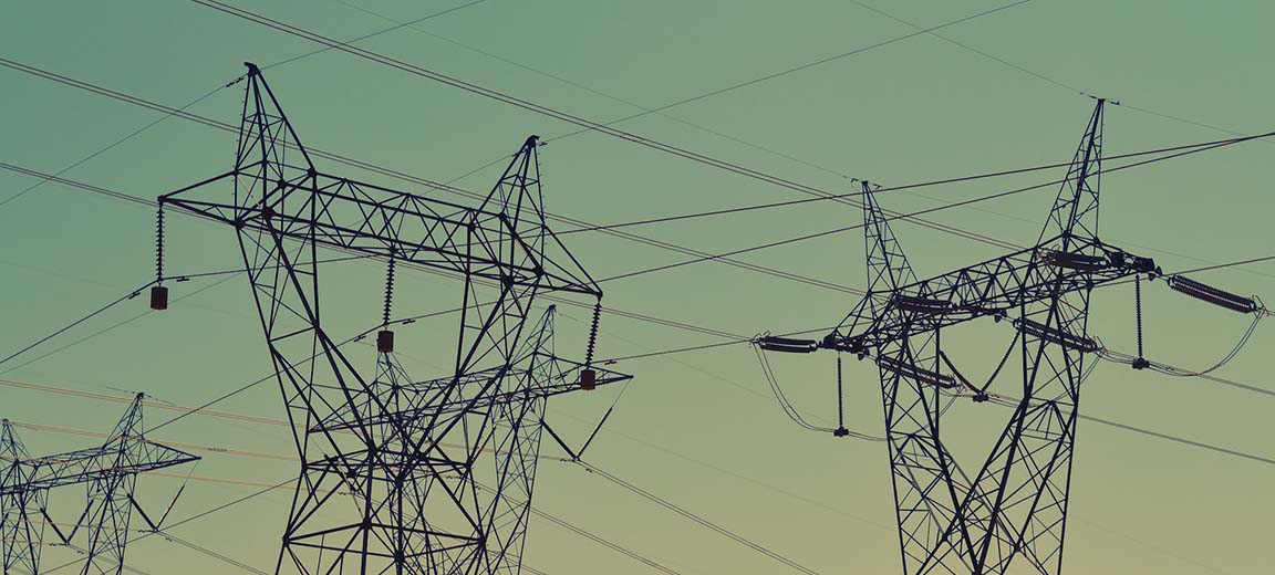 Black transmission towers under green sky. Electricity market
