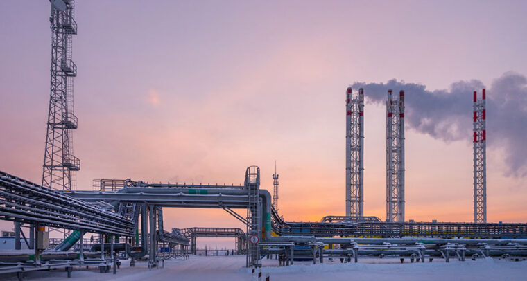 Russian gas production and processing plant near the town of Nov Urengoi. In the foreground a pipeline distribution complex. On the left, a transmission and telecommunications tower, and on the right, three smoke outlet towers