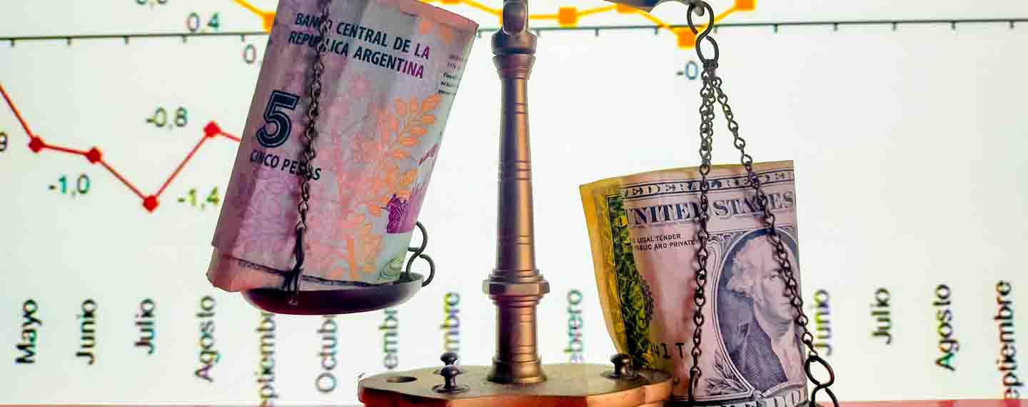 Detalle de una balanza sustentando pesos argentinos y dólares en los platillos. Fondo: Pantalla con gráfico cronológico de las subidas y bajadas de la bolsa.