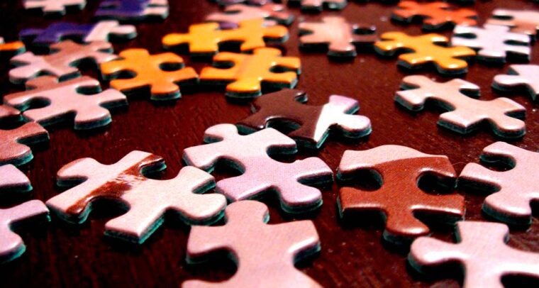 Multicoloured puzzle pieces on a brown table.