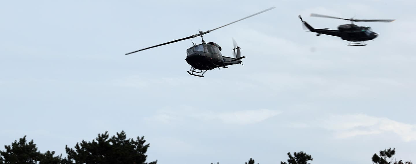 Two European Defence Agency helicopters in an exercise in Hungary. Background: daylight sky.