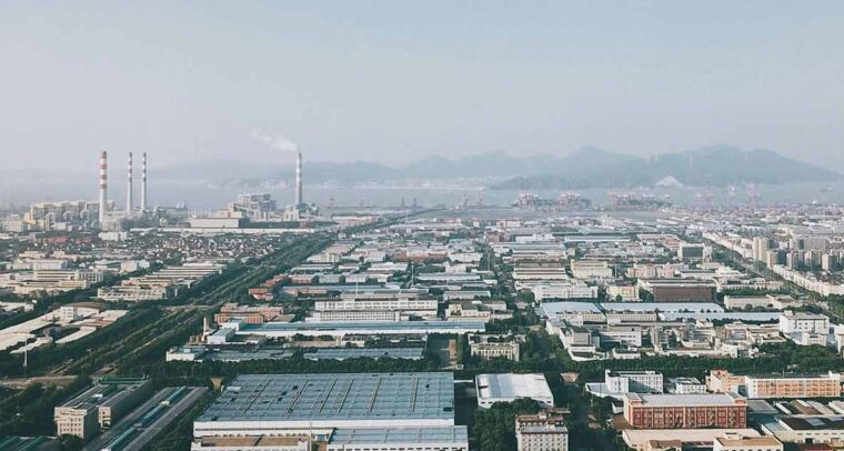 Ciudad de Ningbo Shi, situada en China. Fondo: Distribución industrial de la ciudad con chimeneas.