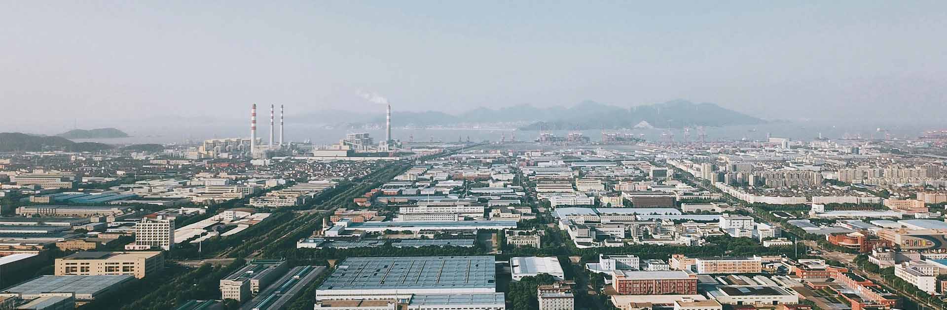 Ciudad de Ningbo Shi, situada en China. Fondo: Distribución industrial de la ciudad con chimeneas.