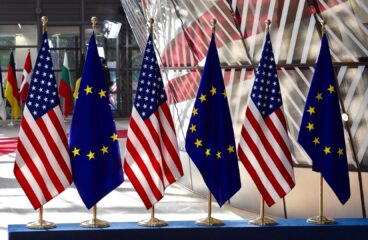 Banderas de la Unión Europea y Estados Unidos alineadas en sus mástiles en la entrada del Parlamento Europeo durante una reunión de dirigentes en 2017