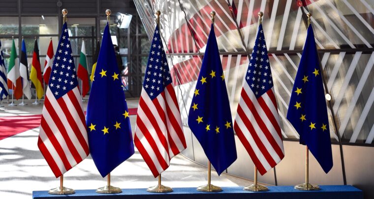 Banderas de la Unión Europea y Estados Unidos alineadas en sus mástiles en la entrada del Parlamento Europeo durante una reunión de dirigentes en 2017