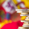 Close-up of stacked euro coins and in the background a blurred Spanish flag. Concept of the Spanish economy
