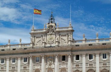 Detail of the façade of the Royal Palace in Madrid with the Spanish flag. King Felipe VI